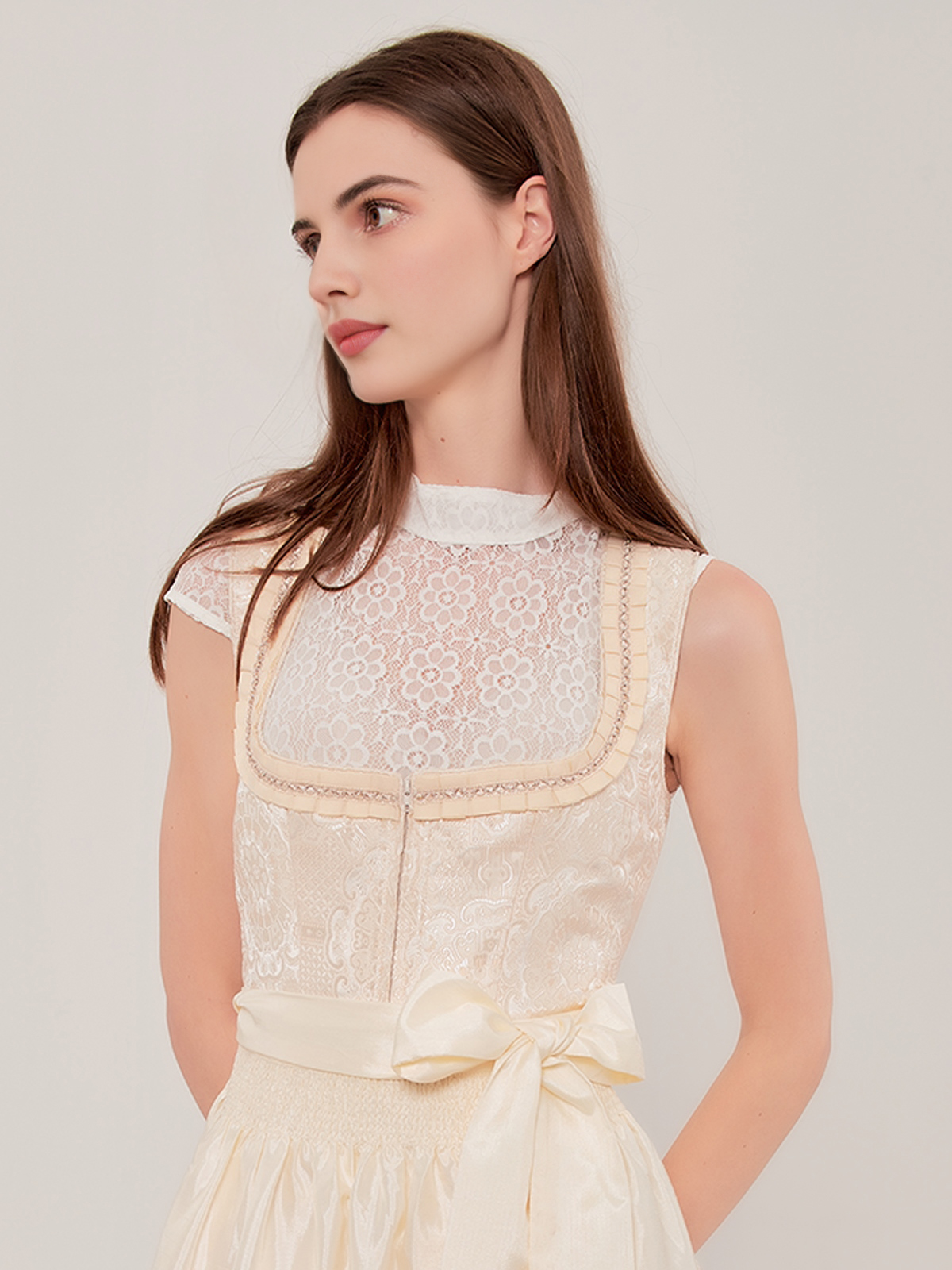 Ein elegantes hellgelbes Dirndl mit Spitzenbesatz